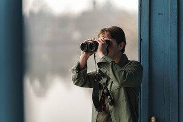 Birdwatching is a hobby that requires attention to detail, patience, and an appreciation for nature. Young guy using professional explorer binoculars for travelers or wild life