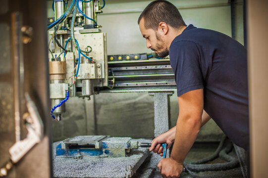Engineer worker technician operating with CNC milling metal engraving machine