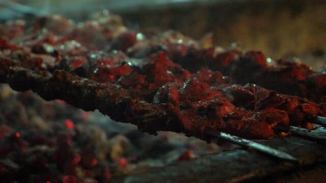 Appetizing Hot Shish Kebab On Metal Skewers Being Turned. Slow Motion, Close Up, Low Angle