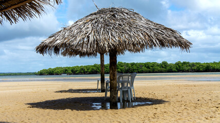 Croa do Goré in Aracaju, Sergipe, Brazil. Straw parasol with shade on the sand. tourist place - obrazy, fototapety, plakaty