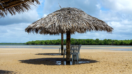 Croa do Goré in Aracaju, Sergipe, Brazil. Straw parasol with shade on the sand. tourist place