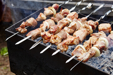 Marinated shashlik preparing on a barbecue grill over charcoal. Traditional Russian shashlik on a barbecue skewer