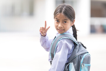 Portrait of a child student in uniform and backpack looking at camera going back to school after covid-19 quarantine and lockdown. Back to School Concept Stock Photo