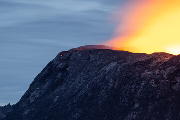 Night volcanic eruption. Fresh hot lava, flames and poisonous gases going out from the crater.