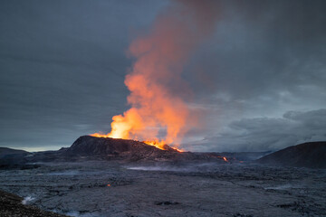 Fototapeta na wymiar Night volcanic eruption. Fresh hot lava, flames and poisonous gases going out from the crater.