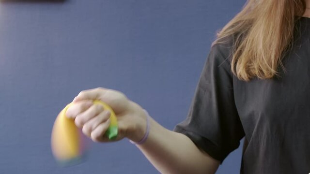 Video of woman shaking banana squishy toy in hand