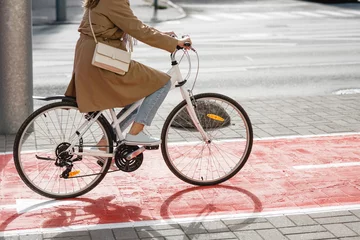 Poster traffic, city transport and people concept - woman cycling along red bike lane or road for bicycle on street © Syda Productions