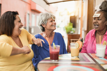 Mature women playing guessing game and having fun at bar outdoor