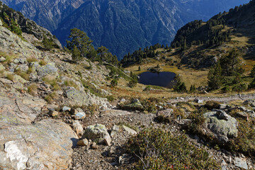 Small blue mountain lake in a forest and rocks landscape