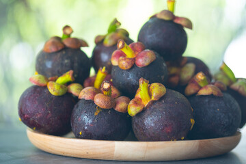 Mangosteen fruit in wooden dish on wood table