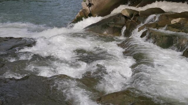Energetic crystalline waters moving over rocky cascade in the Carpathians