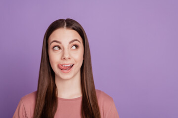 Photo of pretty lady lick tongue teeth lips look empty space isolated on purple background