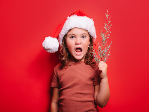 Funny kid in Xmas costume in studio with opened mouth