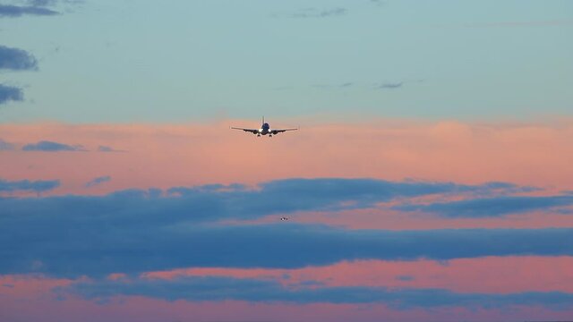 Generic Passenger Jet Airliner Flying in a Vibrant Colorful Sky while on Final Approach into an Airport