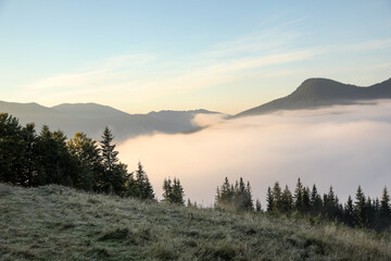 Beautiful view of mountains covered with fog at sunrise