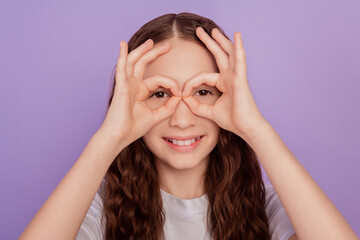 Portrait of little kid girl make okay sign eye isolated over purple background