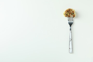 Fork with baked cauliflower on white background