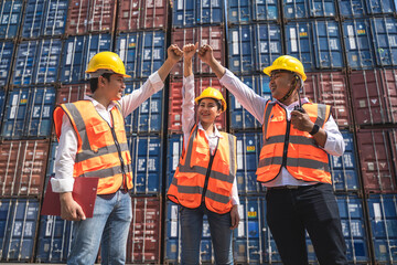 woman worker working with her colleague, standing with ware a yellow helmet to control loading and check a quality of containers from Cargo freight ship for import and export at shipyard or harbor