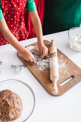 cropped view of african american girl cutting dough with cookie cutter in reindeer head shape