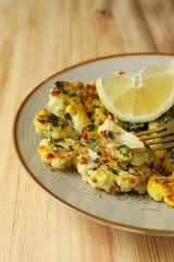 Concept of tasty food with baked cauliflower on wooden background