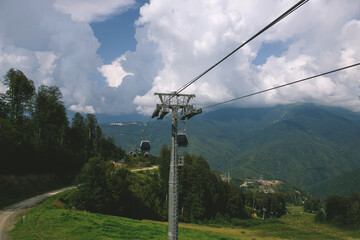 Cable car in the mountains with clouds. View from the cable car to the mountain landscape. The cable car in the fog. The Caucasus Mountains. Sochi district, Russia. cable car without people
