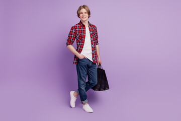Portrait of confident guy hold bargains mall retail black friday concept on purple background