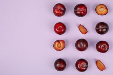 Flat lay composition with plums on purple background