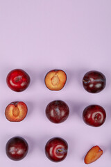 Flat lay composition with plums on purple background