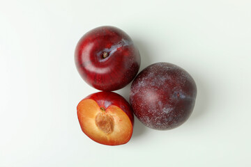 Plums with a half on a white background