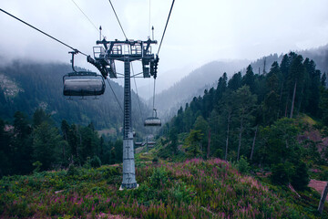 Cable car in the mountains with clouds or fog.View from the cable car to the mountain landscape.The...