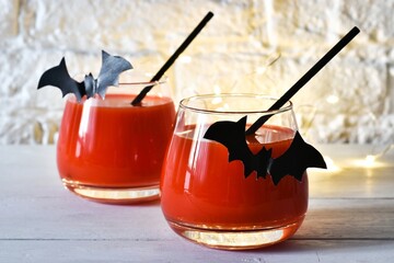 Halloween drinks for kids party. Halloween Cocktail. Food Concept. Glasses with Black Bats on a white brick wall background. Halloween drinks. Selective focus