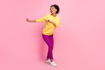 Fototapeta na wymiar Photo of charming shiny woman dressed yellow sweater smiling dancing isolated pink color background