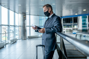 Man with ticket and suitcase in airport hall