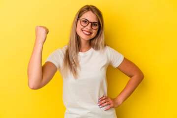 Young russian woman isolated on yellow background cheering carefree and excited. Victory concept.