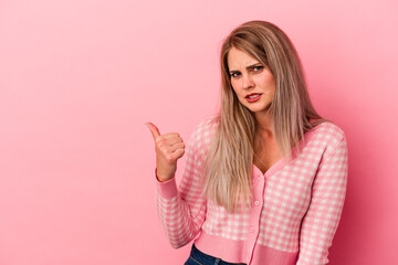 Young russian woman isolated on pink background shocked pointing with index fingers to a copy space.