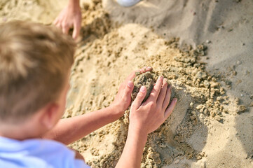 Close up picture of hands making castles from sand