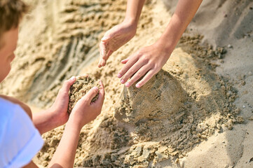 Close up picture of hands making castles from sand
