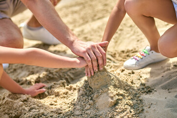 Close up picture of hands making castles from sand