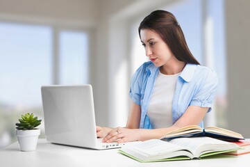 Focused female adult student using laptop, attending online lesson,