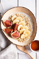 Breakfast with oatmeal porridge decorated with figs and bananas