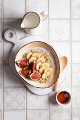 Close up of bowl with porridge with fruits and nuts for breakfast