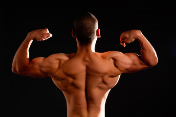 The muscular male back on black background.