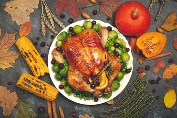 Thanksgiving turkey or chicken for a festive dinner. Food table background with autumn seasonal specialties for Thanksgiving Day. Fried chicken with pumpkin, vegetables and autumn decor on a wooden