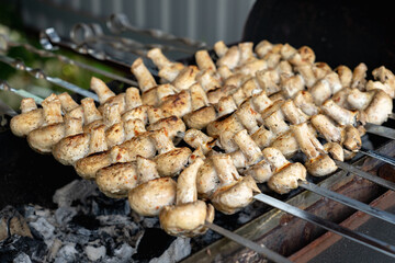 Mushrooms marinated in mayonnaise are grilled. Selective focus