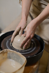 Close up of human hands on a pottery wheel