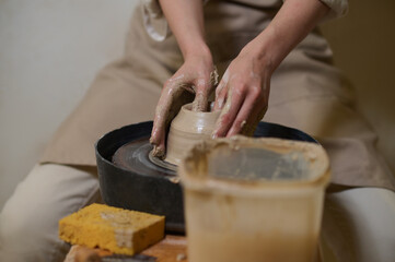 Close up of human hands on a pottery wheel