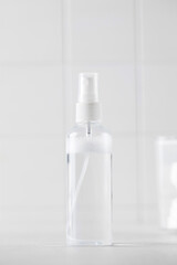 Tonic or facial lotion in a clear plastic bottle on a white background. Daily skin care. Copy space.