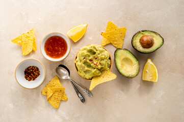 Fototapeta na wymiar Guacamole dip with corn chips, nachos on bright background, party food