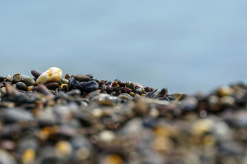 pebbles on the shore with a blurred foreground