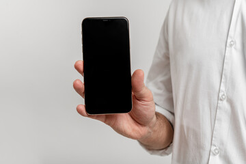 close-up hand holding phone isolated on white, mock-up smartphone blank screen easy adjustment with clipping path